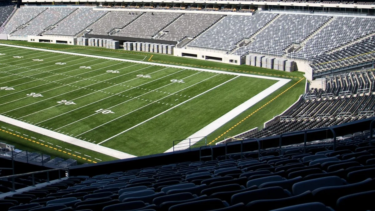 An empty American football field at MetLife Stadium in New Jersey, its turf and yard lines lit by daylight beneath empty stands; illustrative file photograph, not a Sunday Ticket venue or promotional image